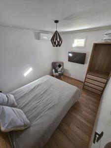 una camera da letto con un letto e una TV a schermo piatto di Appartement cosy proche du Mont-Dore a Laqueuille