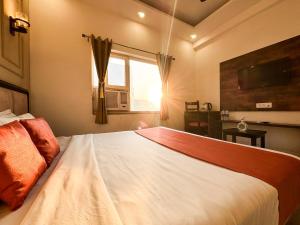 ハリドワールにあるHotel Shoolin Suites Boutique Haridwarの窓のある大きな白いベッドのある寝室