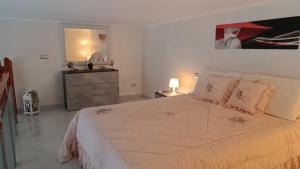 a white bedroom with a large bed and a dresser at Casa Vacanza Raggio di sole in Giovinazzo