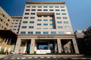 um grande edifício branco com uma placa nele em Asiana Hotel Dubai no Dubai