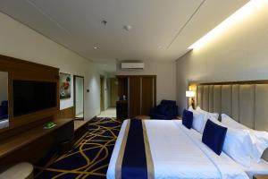 a hotel room with a bed and a flat screen tv at KAREM ALZAHBI HoteL in Al Madinah +2 photos