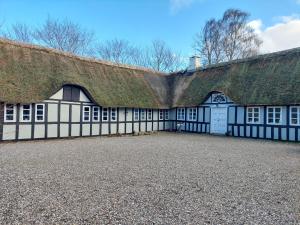 欧登塞Krogsgaardens Bed and Breakfast的黑白的建筑,有草屋顶