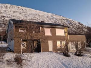 a house in front of a snow covered mountain at apartment With fantastic view and parking in Tromsø