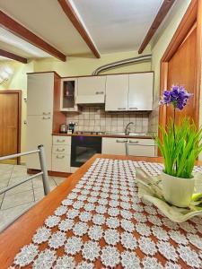a kitchen with a wooden table with a vase on it at La Casa di Malú -5min centro-porto-acquario-stadio-free wifi in Genova
