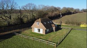 une petite maison assise au sommet d'une pelouse dans l'établissement Tranquil 2-Bed Nature Cottage with Free Parking, à Newick