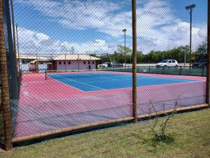 プライア・ド・フォルテにあるVilage Dove Praia do Forteのフェンス越しにテニスコートが見える +6枚の写真