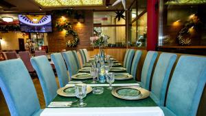 a long table with plates and glasses on it in a restaurant at Комплекс Кремен in Blagoevgrad