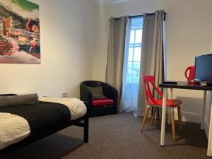 a bedroom with a bed and a desk with a computer at King Street Hotel in Blackburn