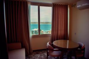 a room with a table and a window with a view of the ocean at Red Sea Hotel in Būr Tawfīq