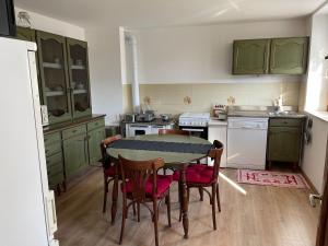 a kitchen with green cabinets and a table and chairs at Casa Marco - Ca' di chi de Zirie - in Pelos