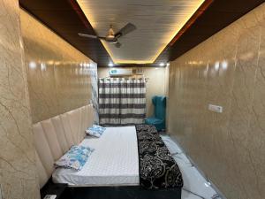 a small room with a bed and a ceiling at Lari Guest House in Gorakhpur