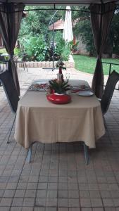 uma mesa com uma toalha de mesa branca em SereNight Guesthouse em Pretoria