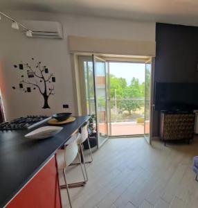 a kitchen with a counter with a tree on the wall at La casa di Andrea in Messina +10 photos