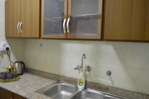 a kitchen sink with a bottle of soap on it at Beautiful Salalah Beach Apartments - 3 By Beautiful Salalah Tours in Salalah +27 photos