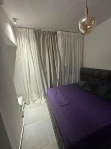 a bedroom with a purple bed in front of a window at luxury apartment Makadi heights phase 2 in Hurghada