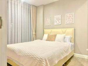 a bedroom with a white bed and a window at Metro luxe riverfront resort style condo in Ban Sai Ma +3 photos