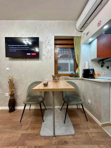 a kitchen with a table and two chairs and a tv at Studio Baščaršija - Sarajevo's prime location in Sarajevo