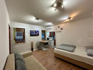 a bedroom with a bed and a couch in a room at Studio Baščaršija - Sarajevo's prime location in Sarajevo