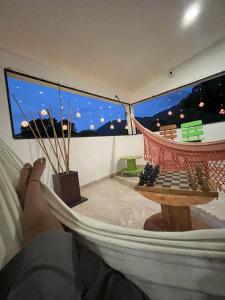 a person laying in a hammock in a room with a chessboard at Casa Bosco Minca in Santa Marta
