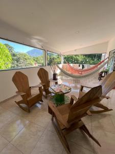 a living room with three chairs and a table at Casa Bosco Minca in Santa Marta