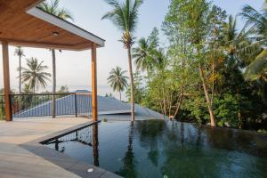 a house with a swimming pool and palm trees at Seaview Villa Ganesha in Ko Phangan