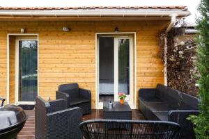 un patio con divani e sedie su una casa di L'escapade parisienne ad Aulnay-sous-Bois