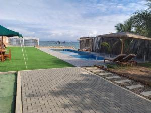 a swimming pool with a gazebo and the ocean at Hospedaje & Casa Playa AURORA in Zorritos +47 photos