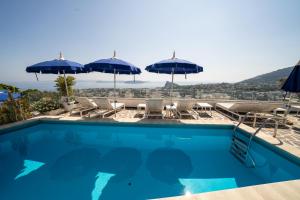 a swimming pool with umbrellas and chairs at Relais Bijoux Ischia in Ischia
