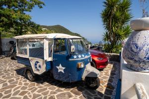 a small blue and white car parked on a sidewalk at Relais Bijoux Ischia in Ischia
