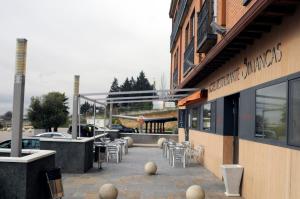 un restaurante con sillas y mesas y un edificio en Hotel Simancas, en Simancas