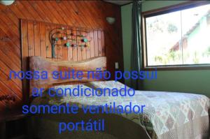 a bedroom with a bed and a window in a room at Suite JC in Visconde De Maua