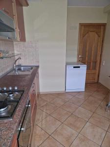 a kitchen with a sink and a stove and a refrigerator at Privatūs apartamentai in Mažeikiai