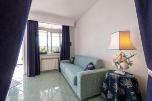 a living room with a blue chair and a lamp at Relais Bijoux Ischia in Ischia