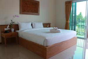 a bedroom with a large bed with white sheets and a window at Crystal Lamai Hotel in Lamai