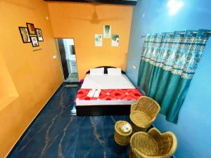 - une chambre avec un lit et deux chaises en osier dans l'établissement Varaha Homestay Hampi, à Hampi 8 autres photos