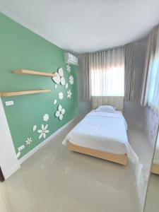 a bedroom with a bed and flowers on the wall at MB Home in Ban Bang Khu +8 photos