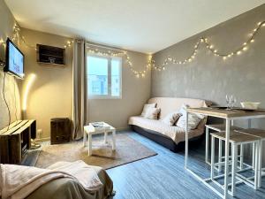 a living room with a couch and a table at Vacances à la mer - studio in Calais