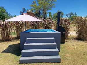 パイサンドゥーにあるRetiro San Francisco 2 hasta 6 huespedes -Pais Uruguayのホットタブ、階段(傘付)