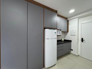 a kitchen with a white refrigerator and cabinets at Sᴛᴜᴅɪᴏ Pʀᴇᴍɪᴜᴍ 513 - Esᴛᴀᴄɪᴏɴᴀᴍᴇɴᴛᴏ - Wɪғɪ - Cᴏᴡᴏʀᴋɪɴɢ- Gʏᴍ in Sao Paulo