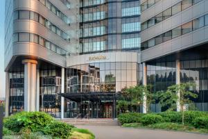 バドフーフェドルプにあるCorendon Amsterdam Schiphol Airport, a Tribute Portfolio Hotelの看板が貼られた高層ビル