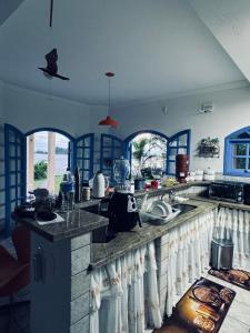 une cuisine avec des murs bleus et un comptoir. dans l'établissement Casa beira mar Angra dos Reis, à Angra dos Reis