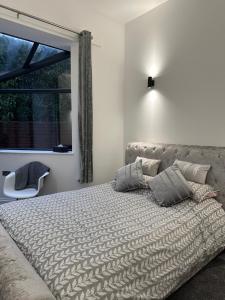 a bedroom with a bed and a window and a chair at Medstead Lodge in Four Marks