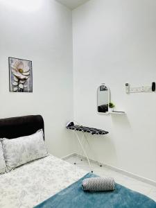 a white bedroom with a bed and a shelf at Aila Homestay TTHI in Alor Setar
