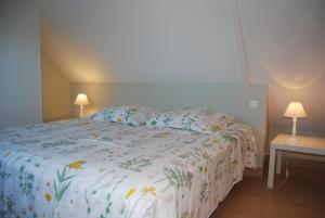 a bed in a bedroom with two tables and two lamps at Maison de pêcheur à 1,5km de la mer in Blainville-sur-Mer