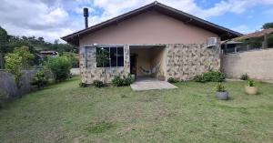 une petite maison avec une cour en face dans l'établissement Casa da Naná - Praia da Gamboa - Garopaba, à Garopaba