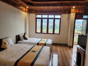 a bedroom with two beds and a large window at Cao Bang Clover House - Hotel & Motorbike Rentals in Cao Bằng