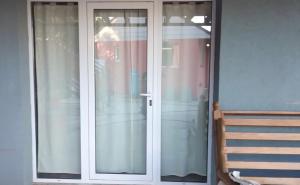 a glass door to a porch with a wooden bench at Tres Piquillines in Puerto Madryn