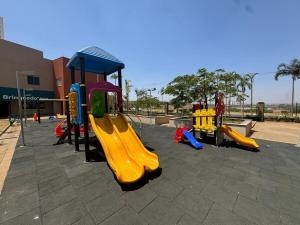 a playground with three slides and a play structure at Apto Solar das Águas Olimpia SP in Olímpia