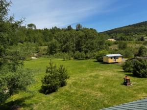 a large grassy field with a house in the background at le Studio in Tadoussac