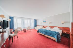 a hotel room with a bed and a television at Hotel Lidia Spa & Wellness in Darlowko +68 photos